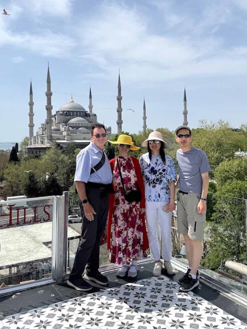 A photograph of Barry, Liping, Wenyu, and Chuanpu in front of the Blue Mosque taken from Seven Hills Restaurant near Sultanahmet Park