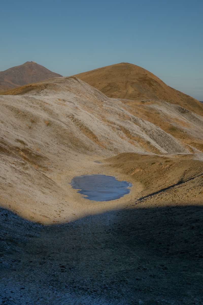 A small frozen alpine lake near Lago Scaffaiolo during colder months.