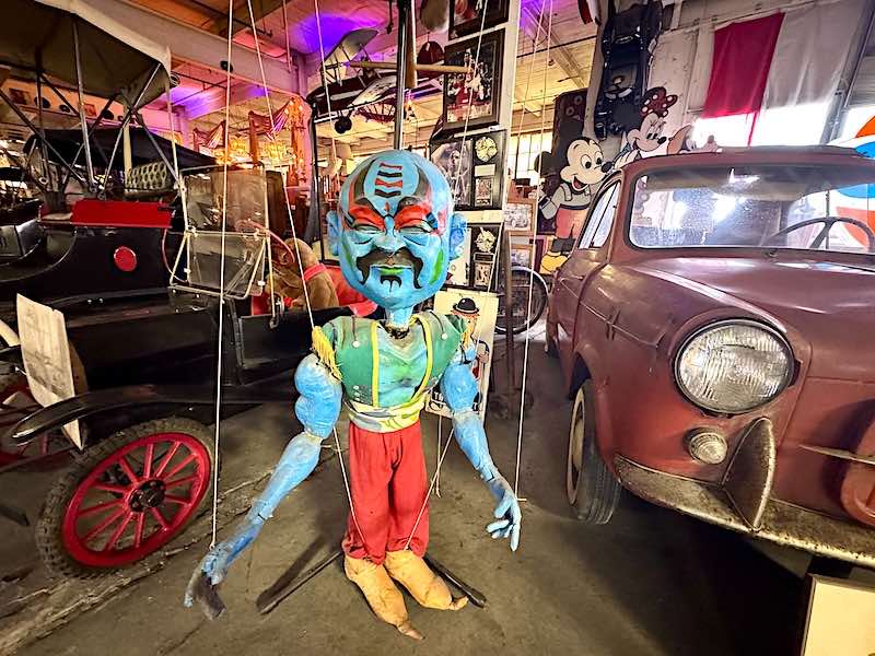 A large puppet displayed in the Classic Cars section of the American Treasure Tour Museum